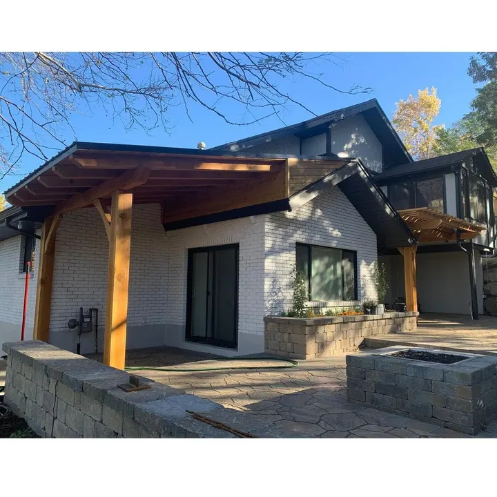 Attached timber patio cover beside a home with stone trim
