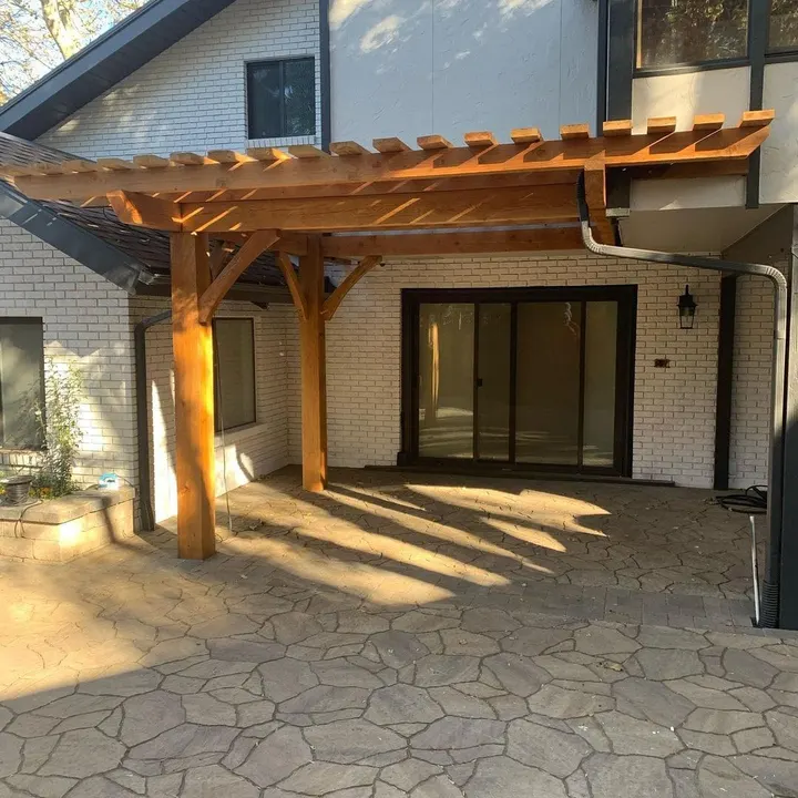 Attached timber patio cover over a stone-paved seating area