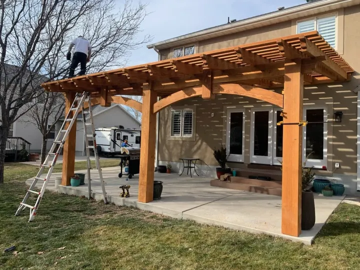 Attached pergola under construction beside a home