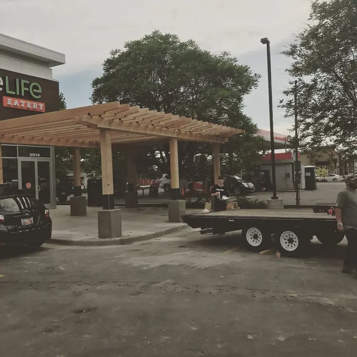 Pergola installation in a paved commercial plaza