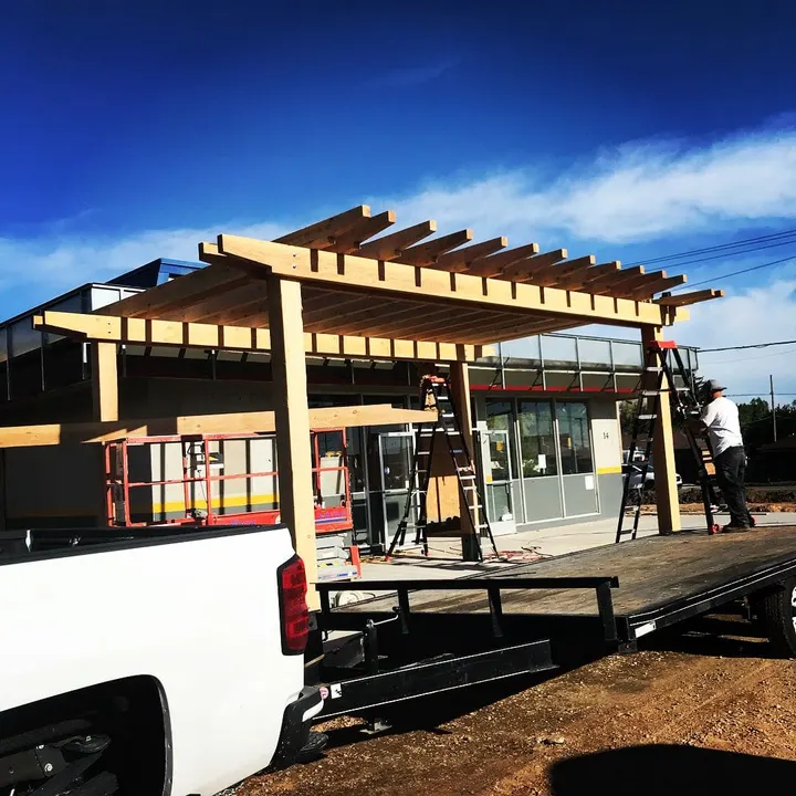 Open-lattice pergola across a commercial storefront