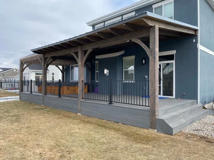Roofed timber patio structure integrated with a blue home