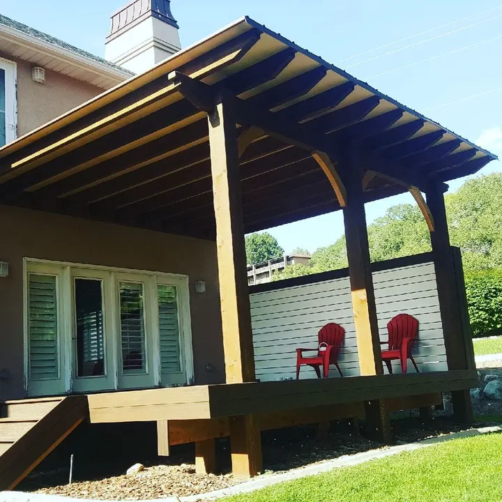 Timber-covered porch with two red chairs