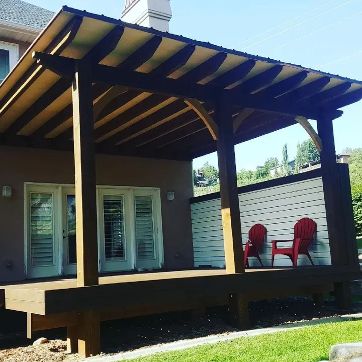 Wide view of a covered porch with two red chairs