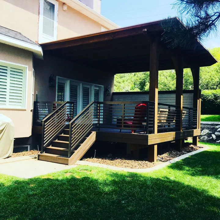 Covered raised deck with black railing and stairs
