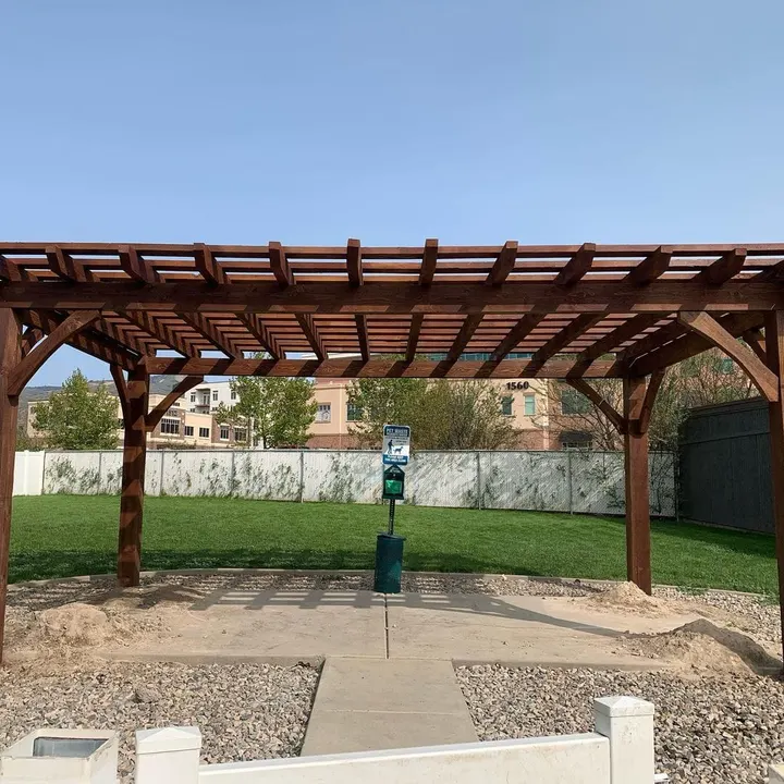 Freestanding open-lattice pergola in a fenced backyard