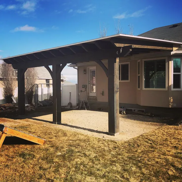 Freestanding timber patio cover over a gravel area