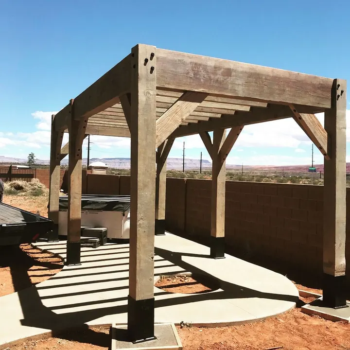 Freestanding pergola beside a block wall