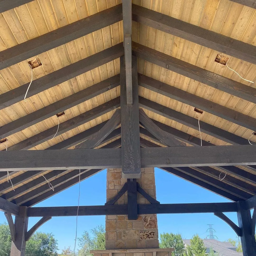 Upward view of timber pavilion rafters and gabled ceiling framing