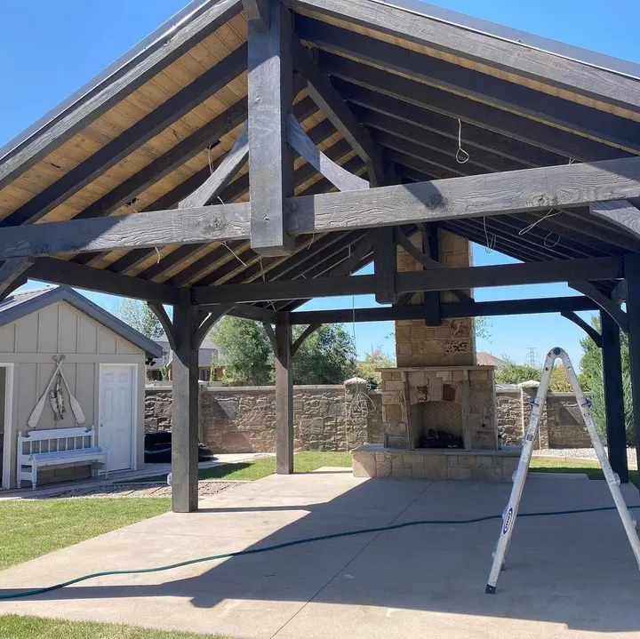 Wide view beneath a gabled pavilion with stone fireplace