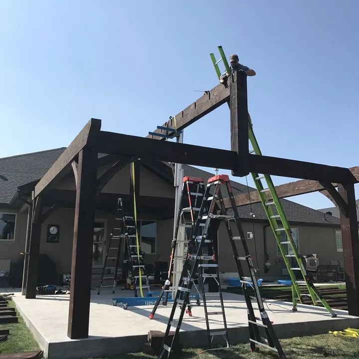Gabled pavilion frame under construction with ladders