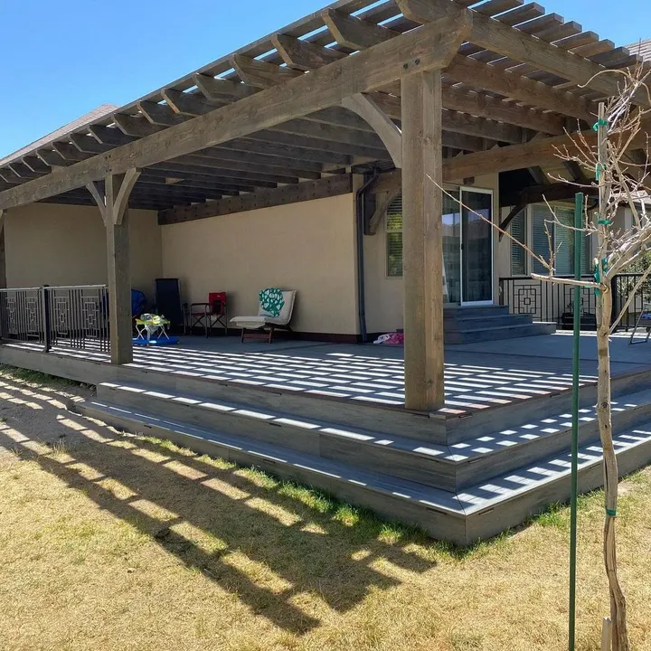 Open-lattice patio cover casting striped shadows across the deck