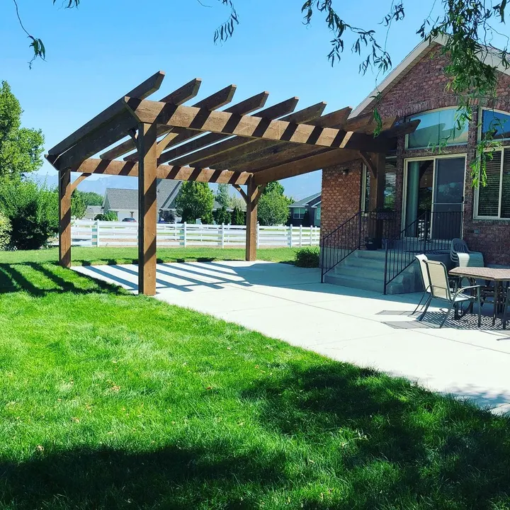 Open-lattice pergola viewed across a green lawn