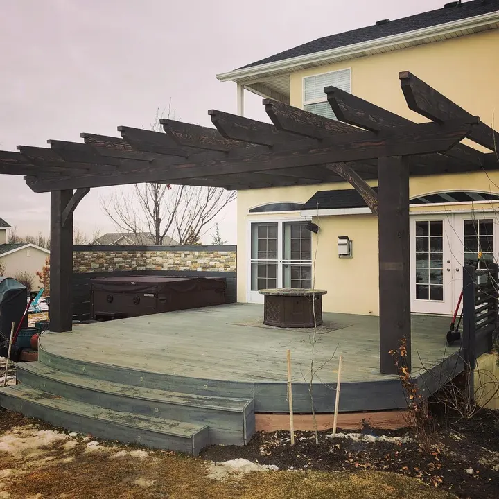 Open-lattice pergola over a curved backyard deck