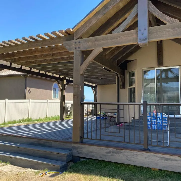 Open-lattice timber cover over a raised deck beside a home