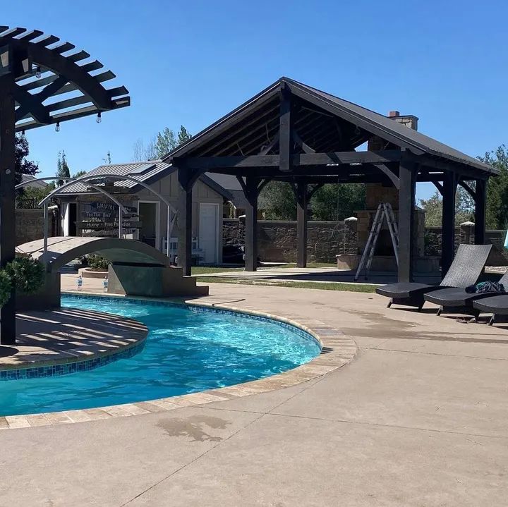 Gabled pavilion beside a swimming pool and lounge area