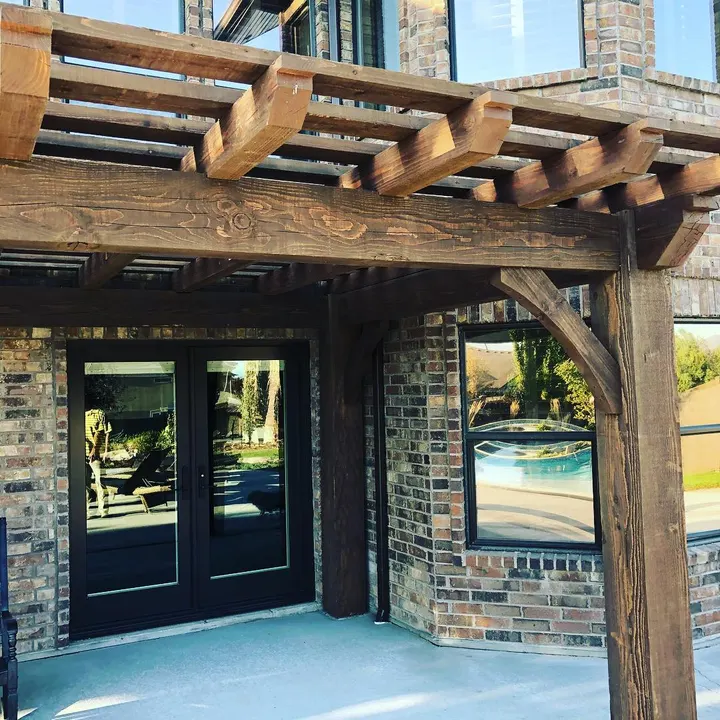 Rustic open-lattice pergola over an outdoor kitchen