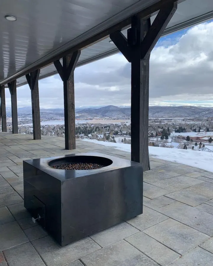 Covered patio and fire pit overlooking a snow-covered valley