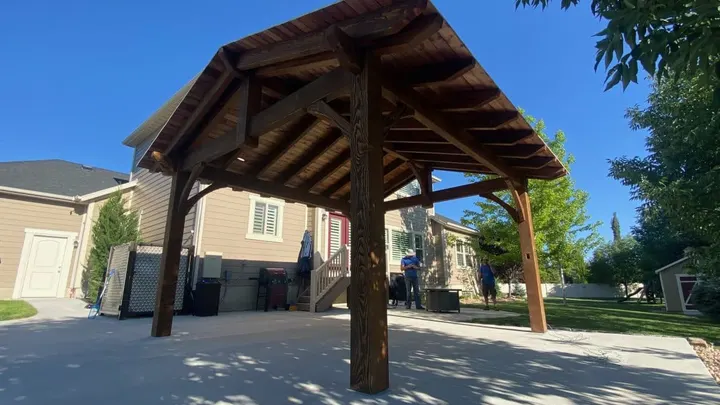 Freestanding gabled timber pavilion over a driveway