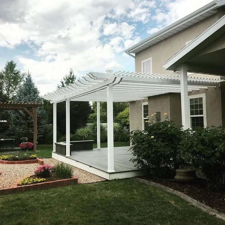 White pergola over a landscaped backyard patio