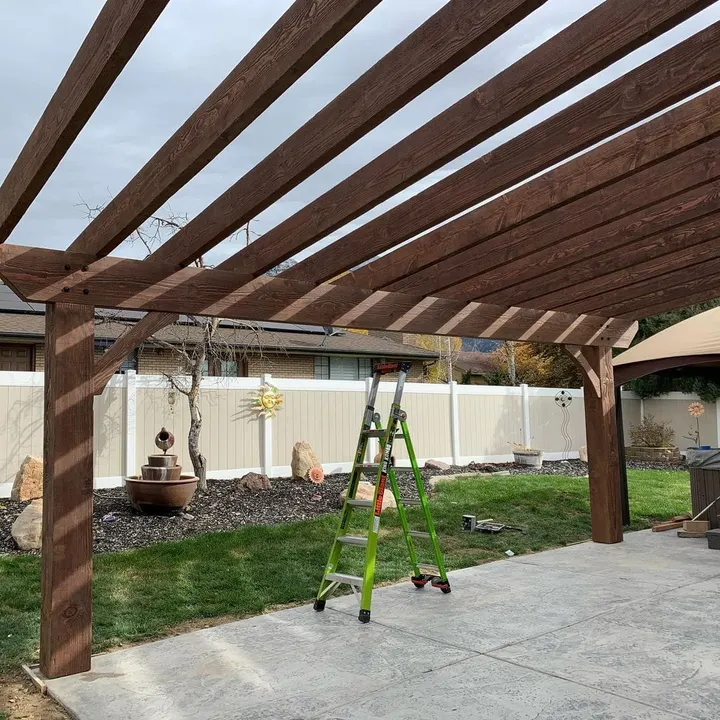 Wide open-lattice pergola spanning a backyard patio