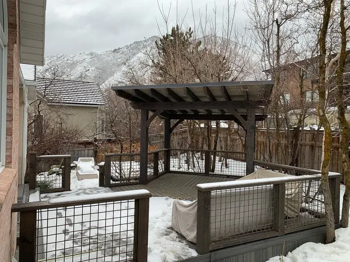 Wide winter view of a raised deck and pergola