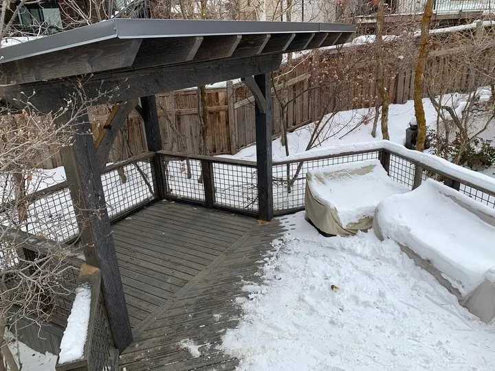 Side view of a pergola and snow-covered deck
