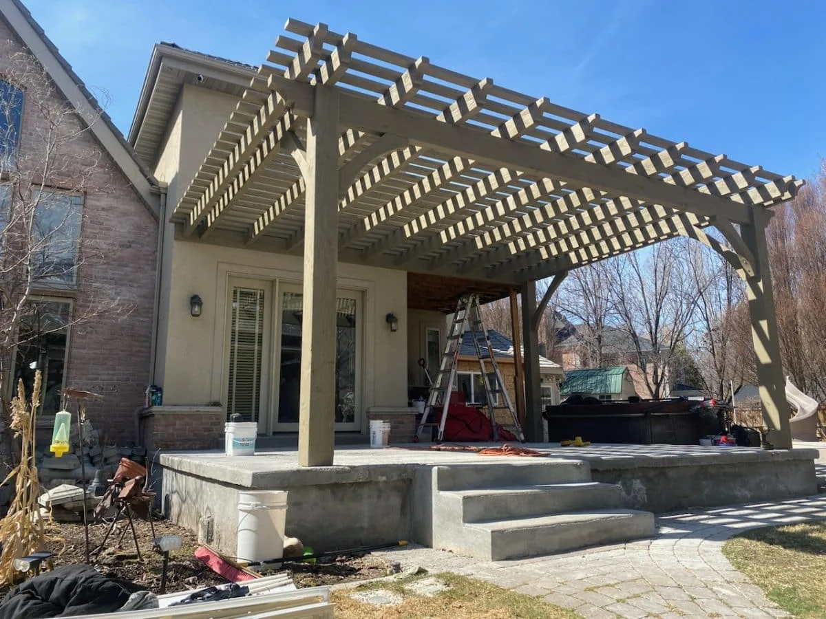 Gray-finished attached timber pergola beside a home
