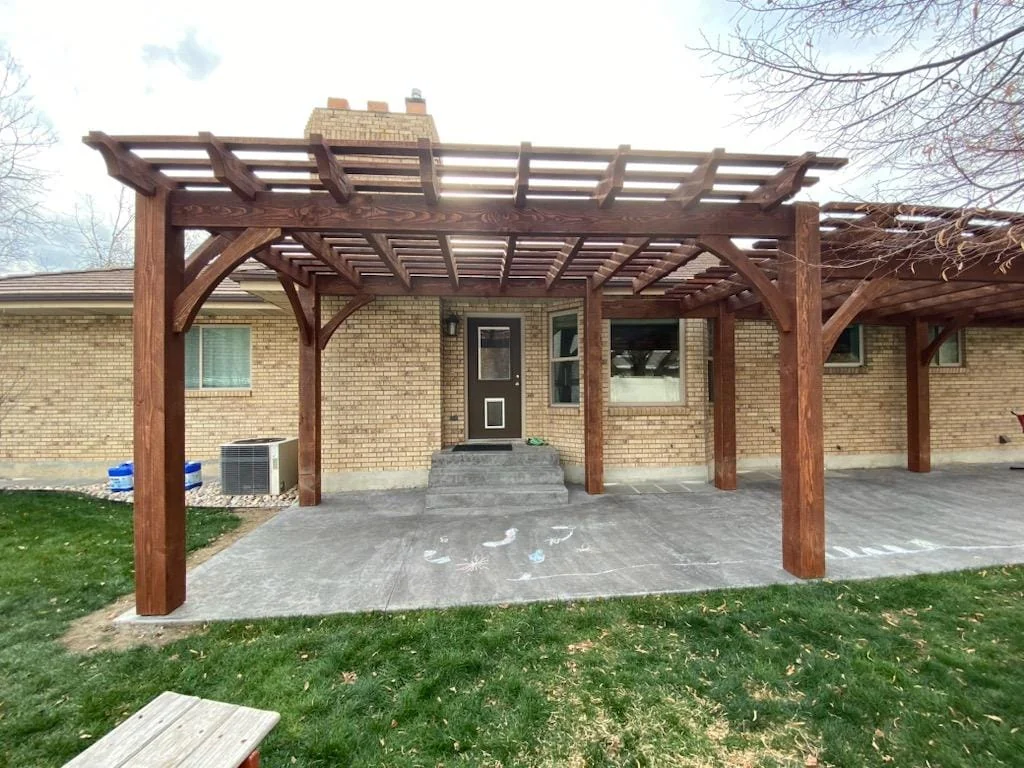 Freestanding timber pergola built behind a Utah brick home